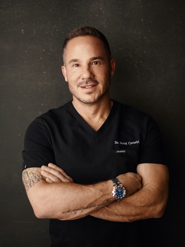 Dr. Jarrod Cornehl, cosmetic dentist in San Francisco, smiling for a picture with his arms crossed.